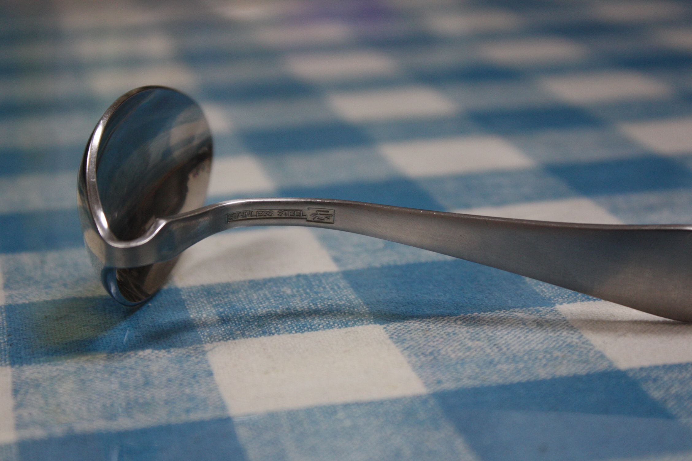 there is an aluminum spoon lying on the table