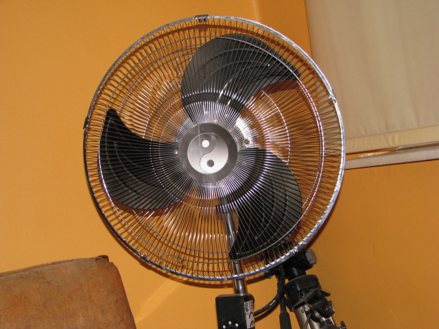 an industrial fan mounted in the corner of a room