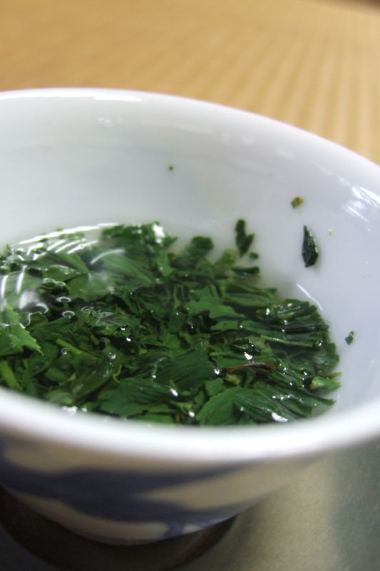 small bowl of vegetable greens on a wooden table