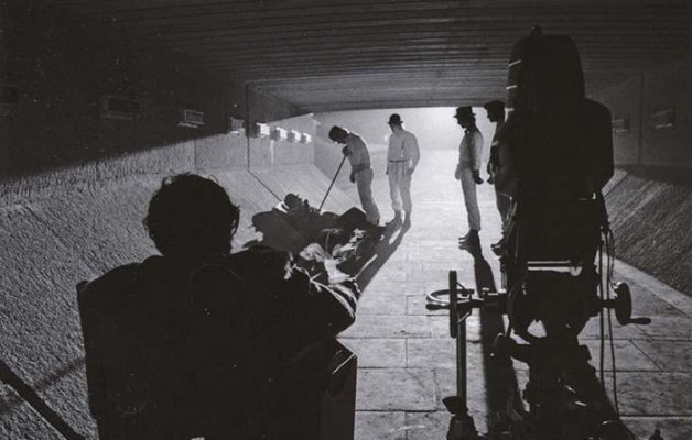 four people walking in a tunnel behind bicycles