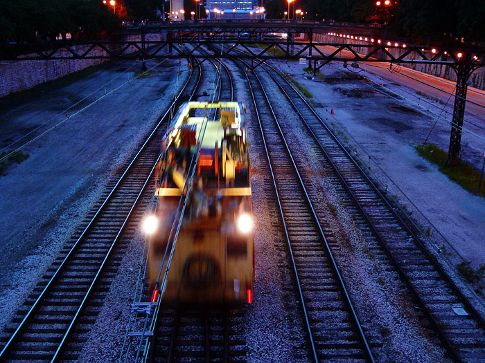 two trains traveling down a train track at night