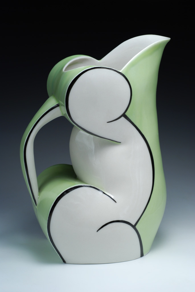 a white and green vase sitting on top of a table