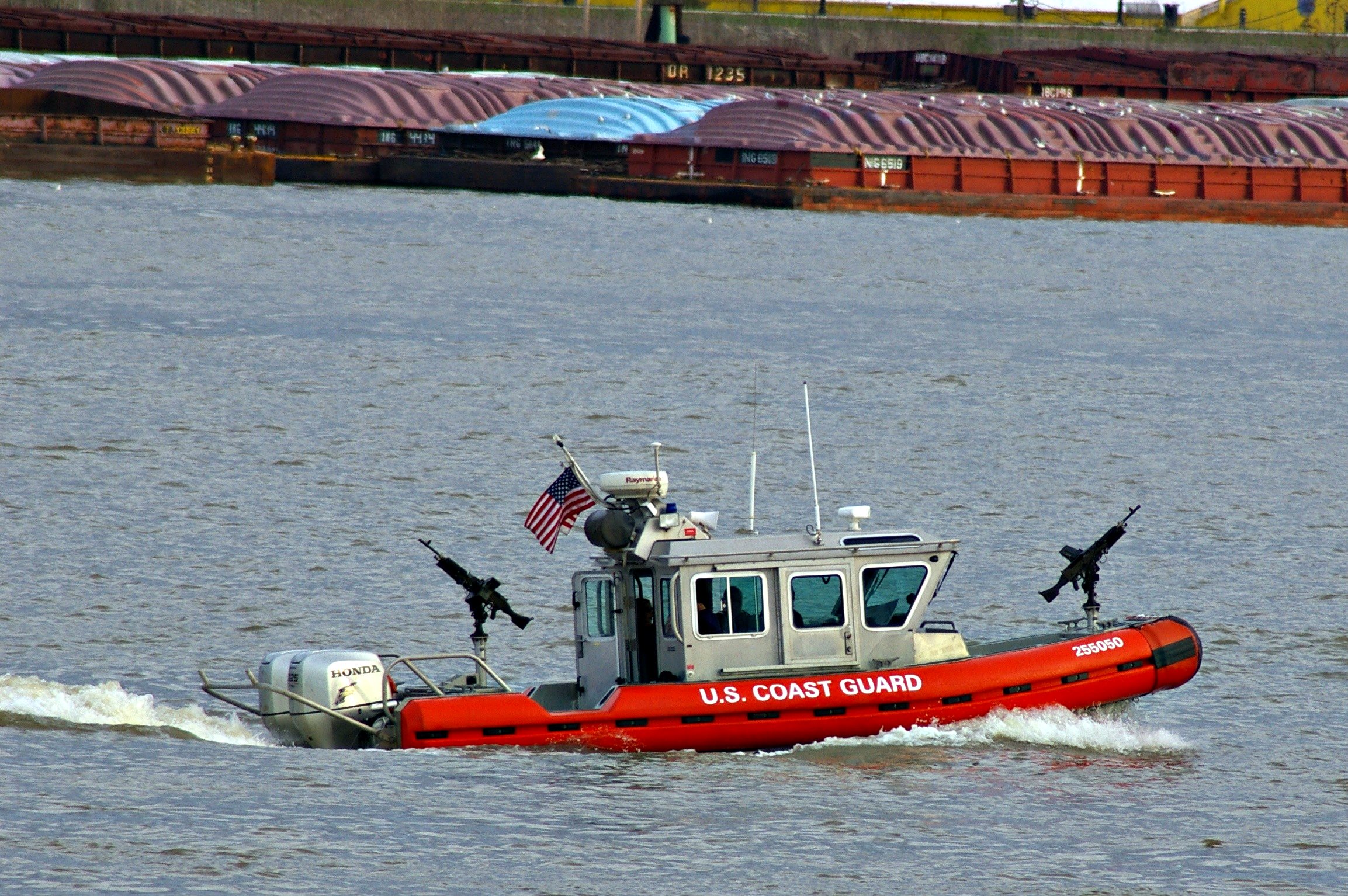 a coast guard boat on the water with two birds on it
