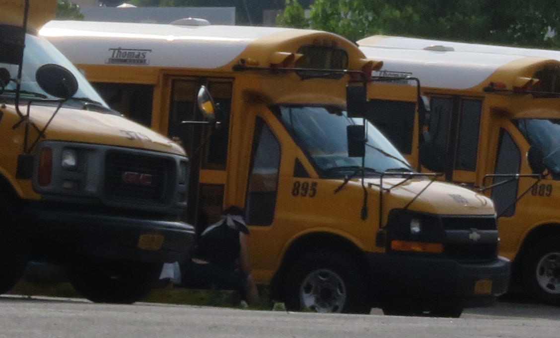 four school buses lined up in a parking lot