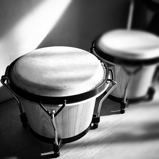two wooden drums are sitting on a wooden floor
