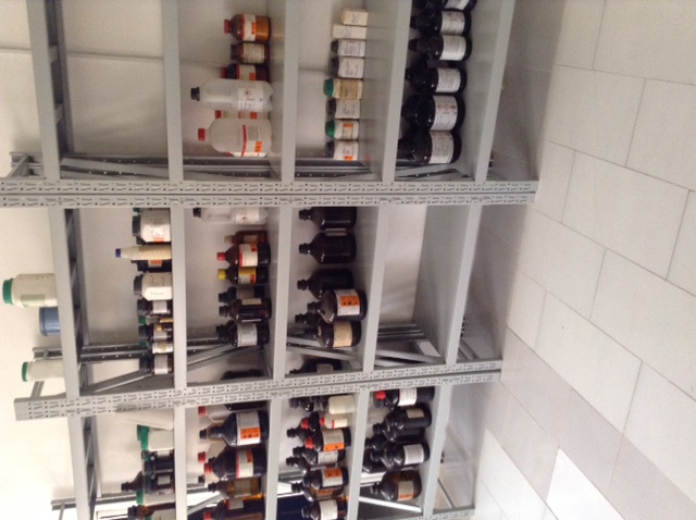 a shelving unit full of bottles and various medicine related items