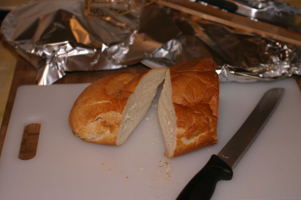 a white  board with a sandwich on it and a knife