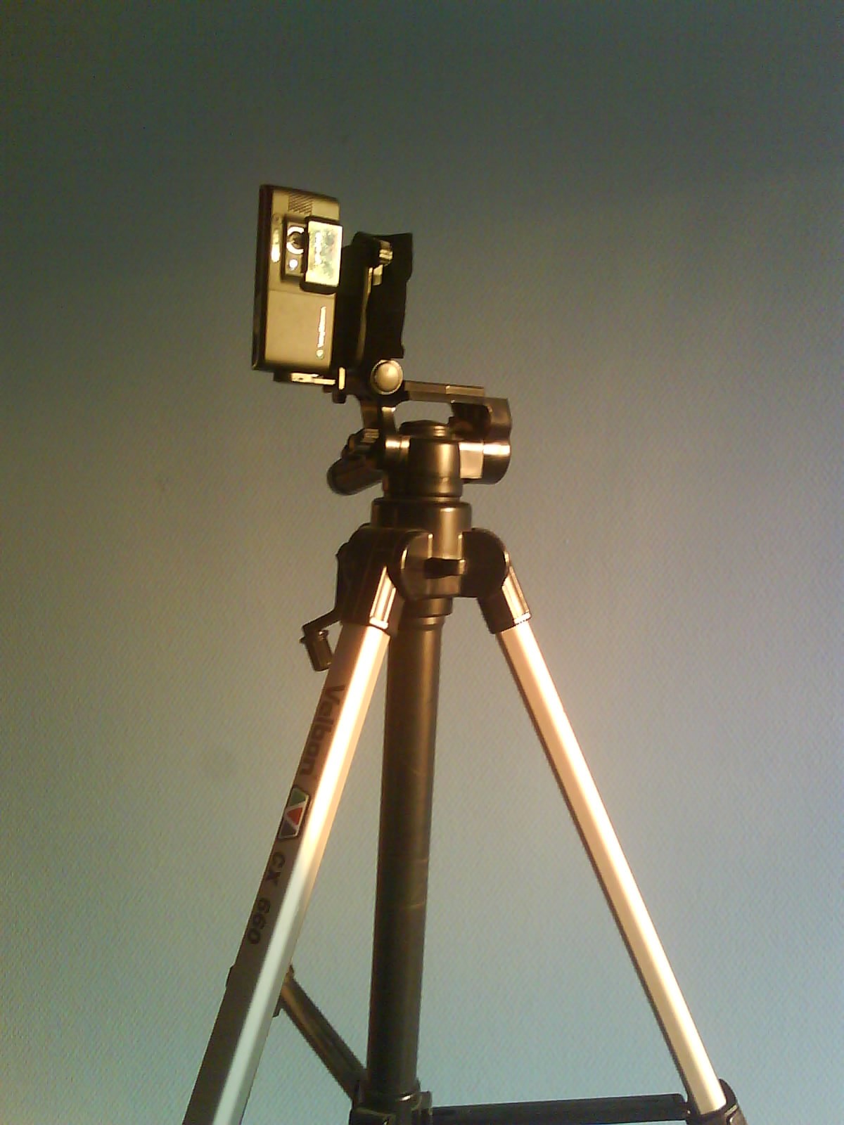 a tripod holding a camera and some kind of item