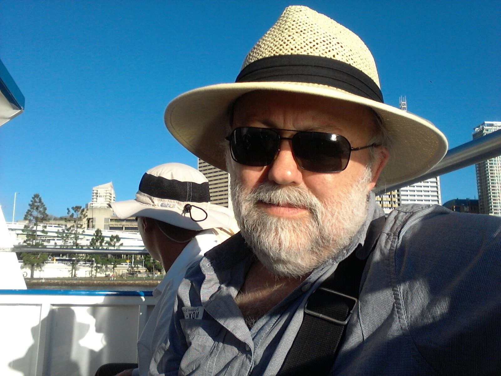 a man with sunglasses and a hat in his hand is on a boat