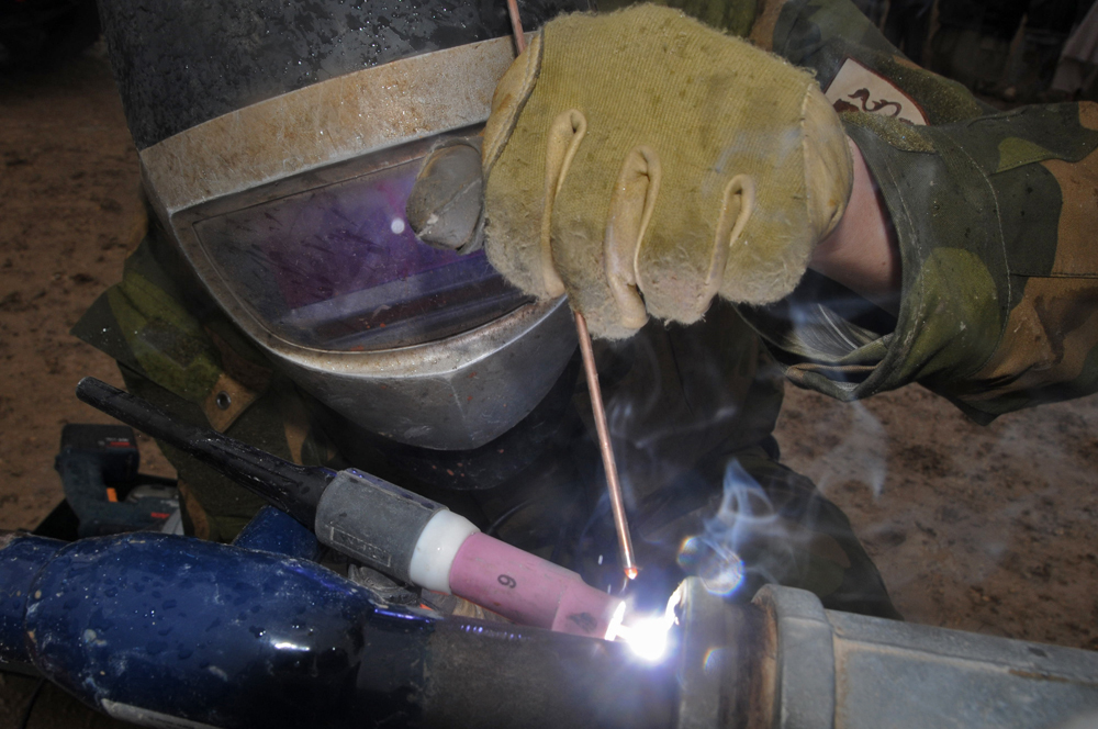 a welder is grinding soing on the pipe