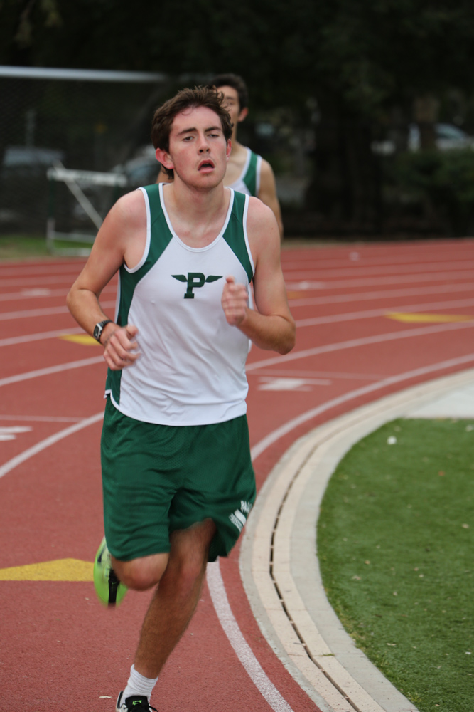 a man on a track wearing green and white running
