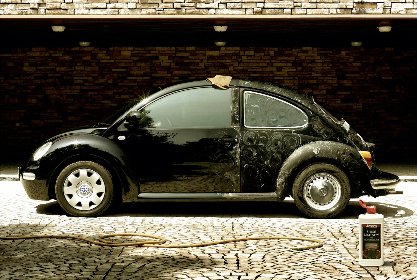 an old beetle parked in front of a brick wall