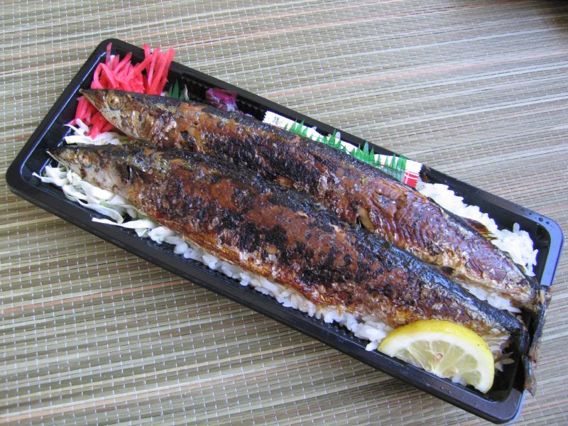 some fish with rice and lemon on a tray