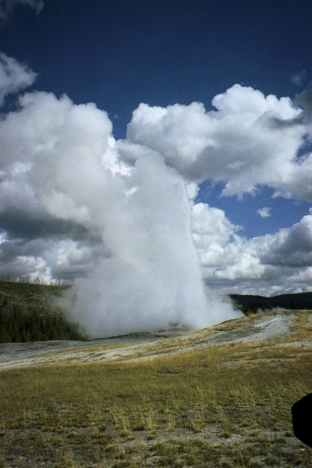 there is a large, steaming geyser on a field