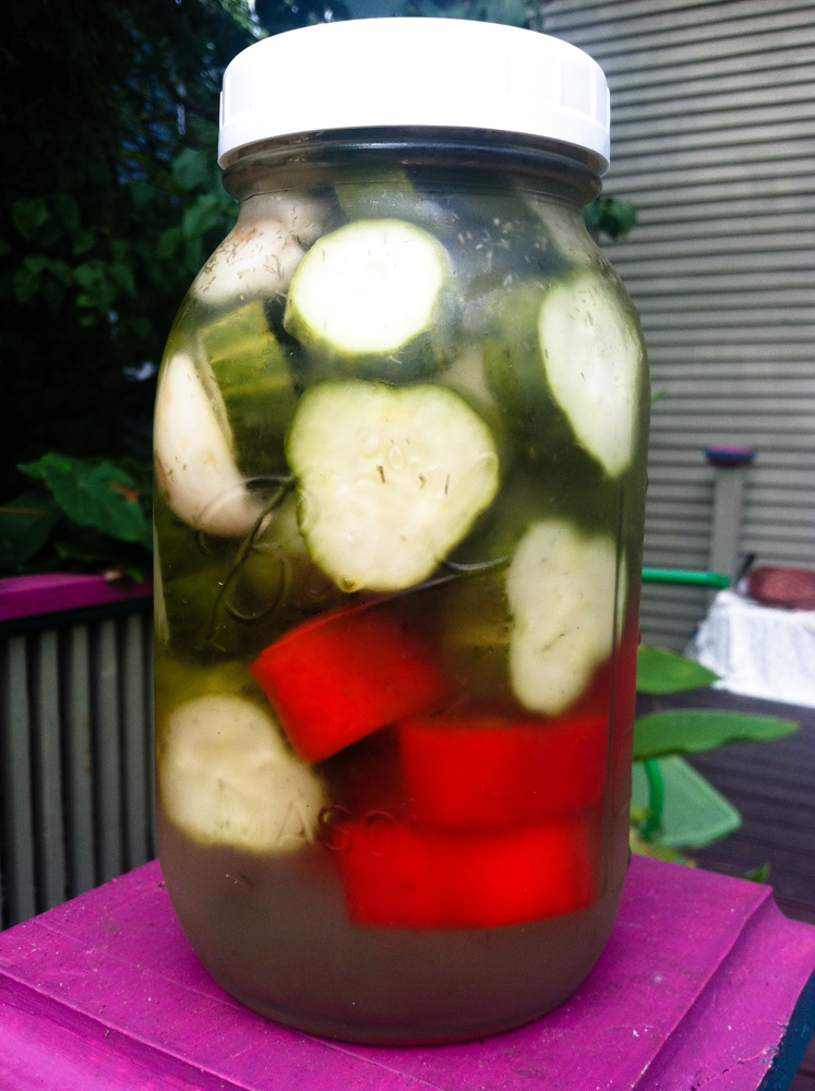 a jar with a bunch of pickles and water on top