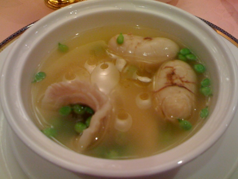 a bowl filled with green pea soup and clam