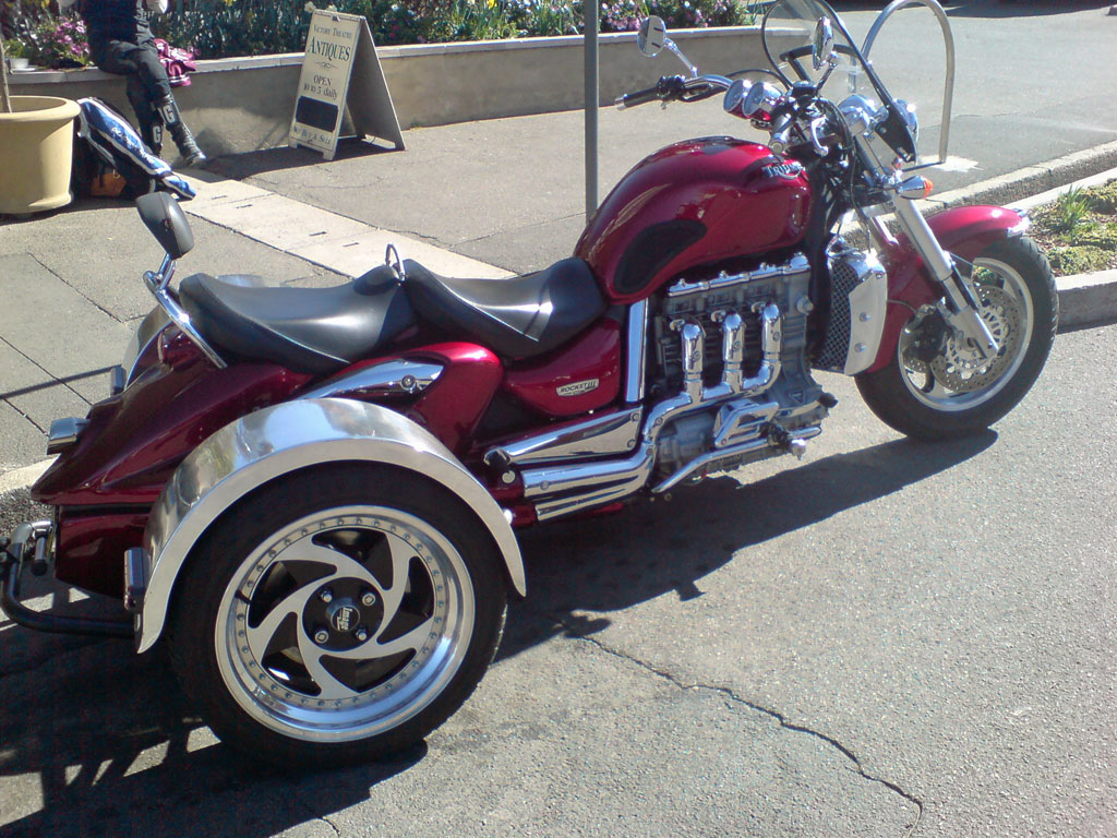 a very nice looking red motorcycle by the curb