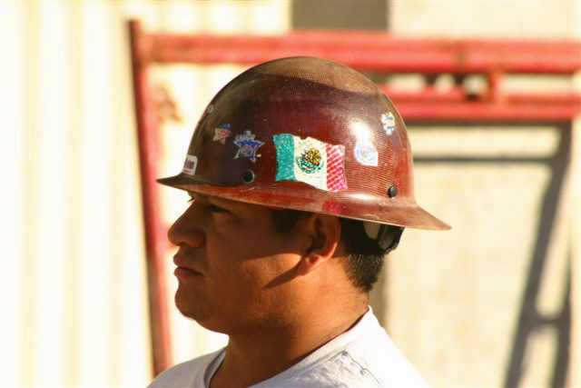 a man is wearing a hard hat with various stickers on it