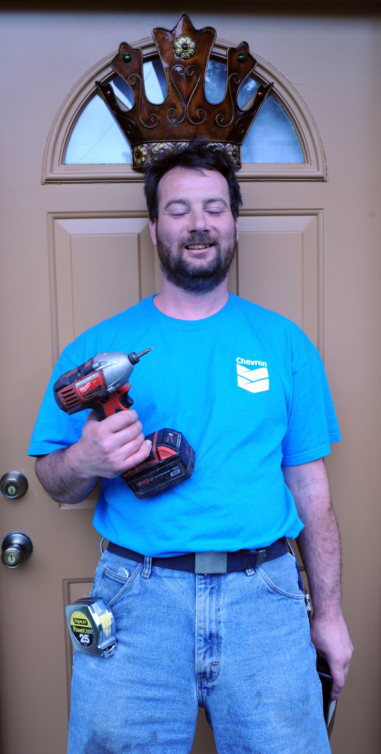 man in blue shirt with beard holding a drill hammer