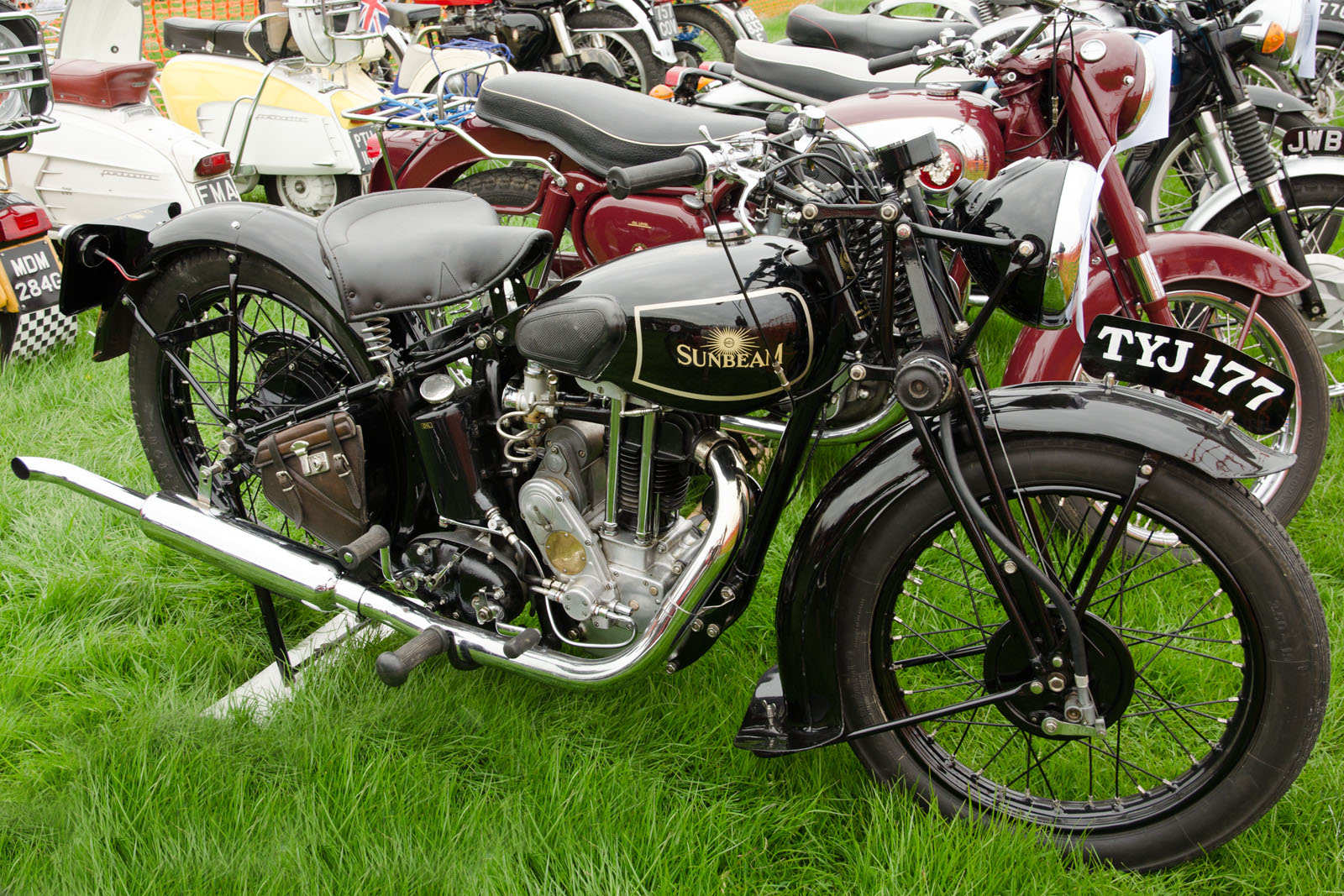 the motorcycles are parked side by side on the grass