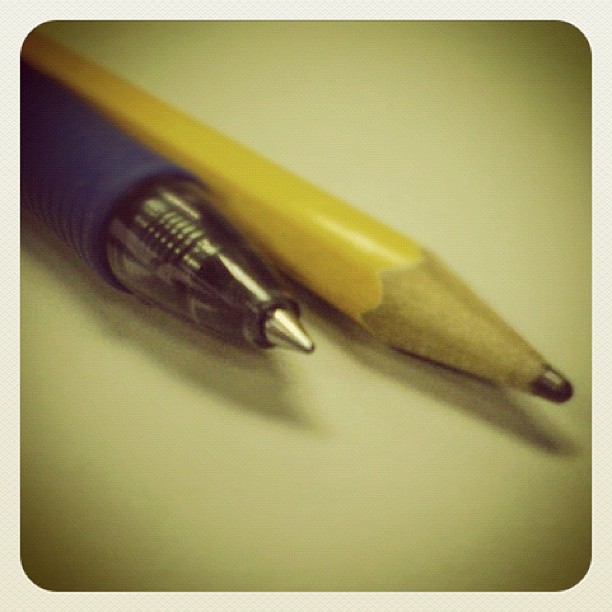 a blue and yellow pencil on a white surface