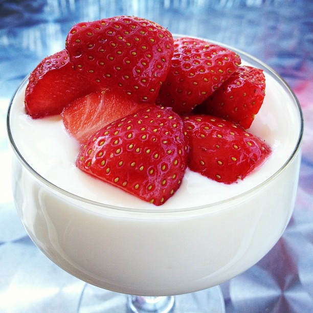 a strawberry garnish in a glass bowl filled with milk