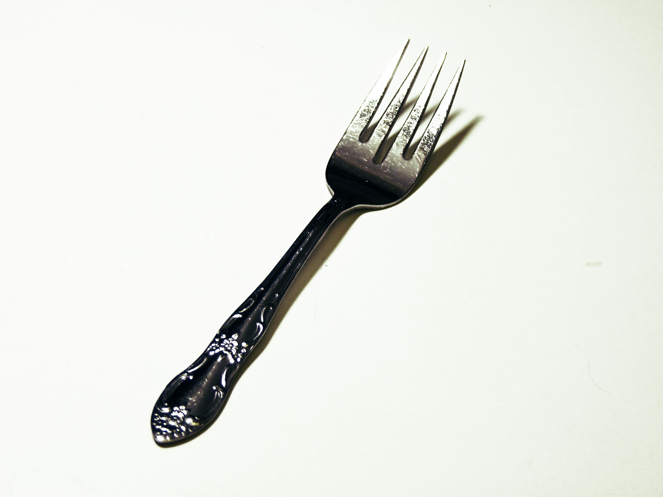 a fork sitting on top of a white surface