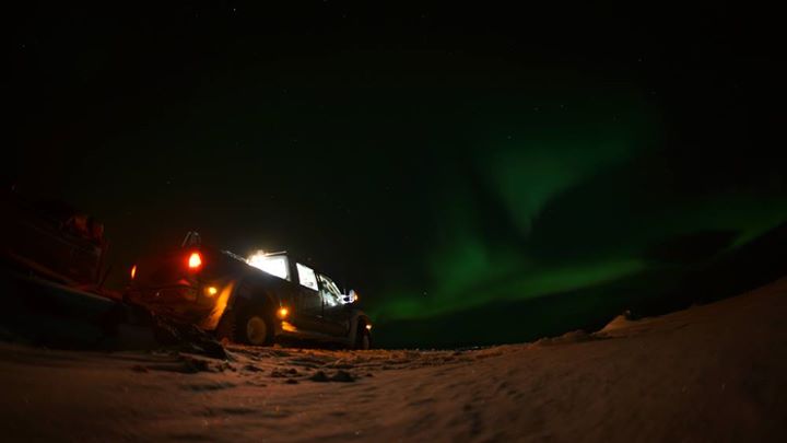 a tractor and an aurora light are seen in the background