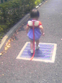there is a small girl on the road with a bag