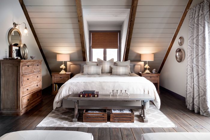 a bed sitting under two tall wooden beams