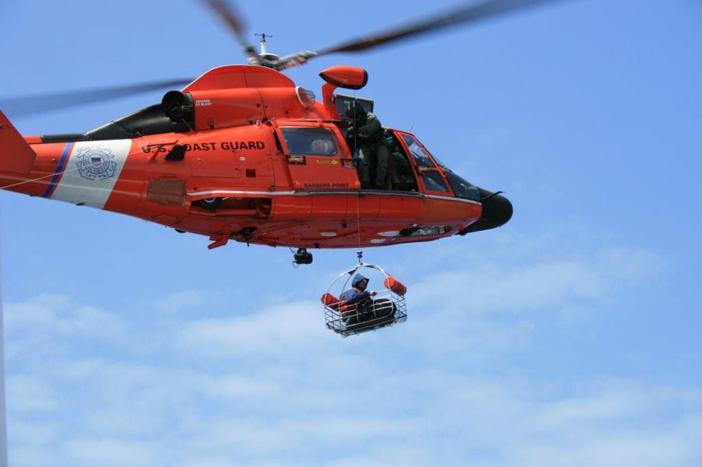 an helicopter being lowered by a man in the air