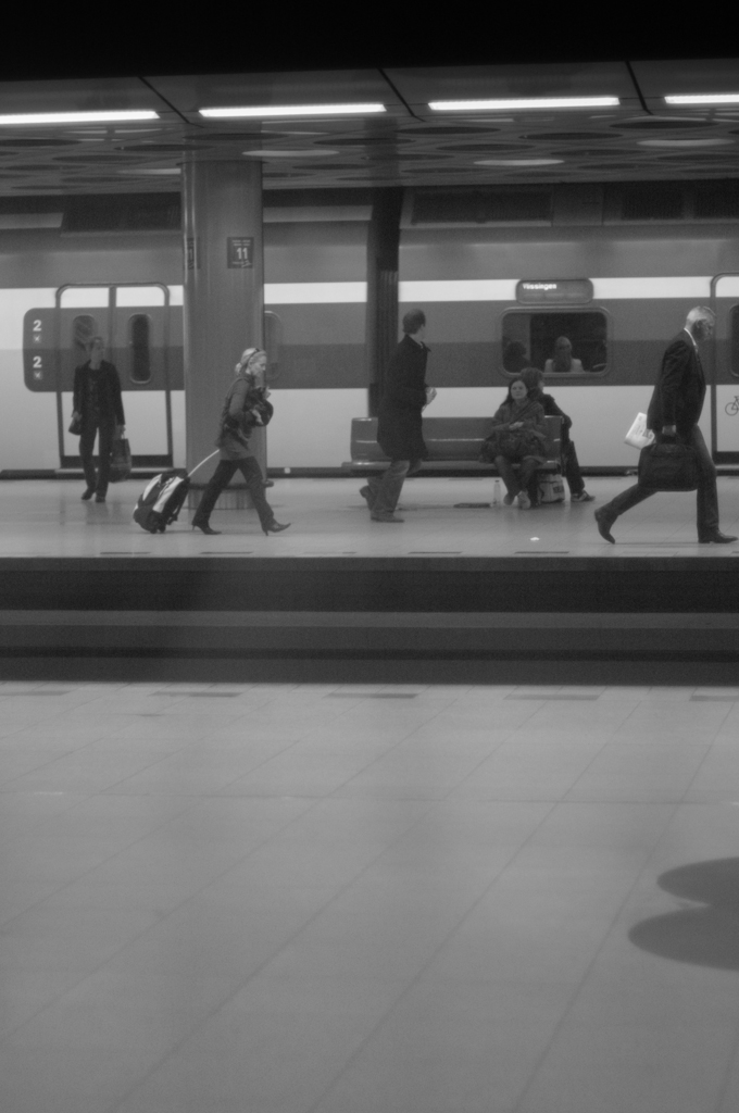 some people are sitting on the ground in a subway station