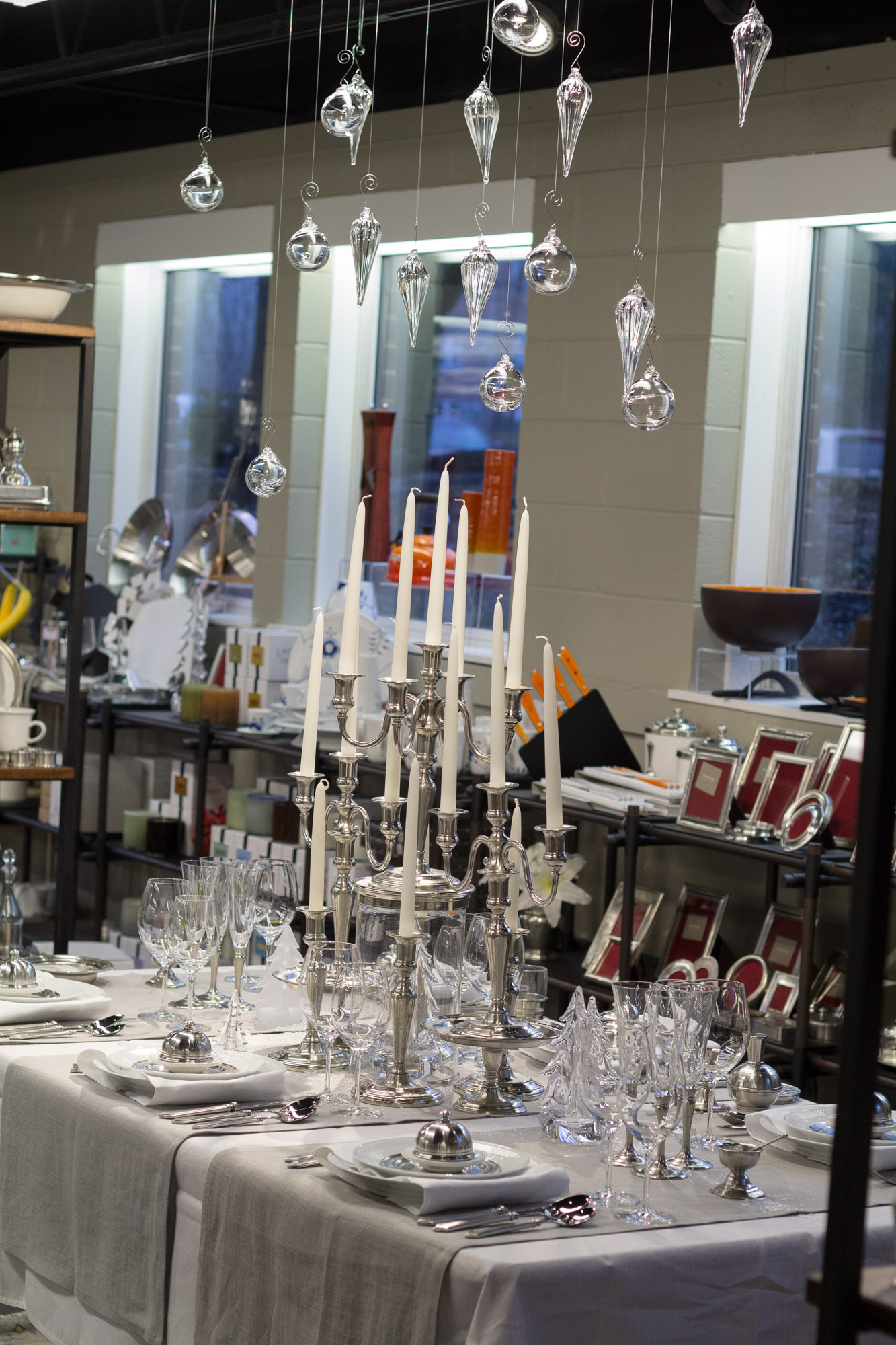 a table set up with several empty glasses and silver candles