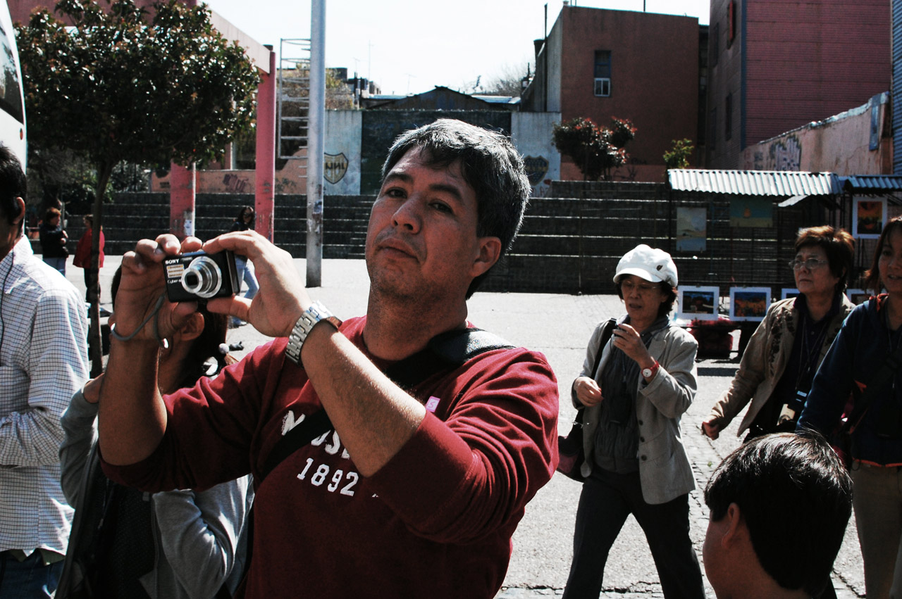 a man is holding up his camera in front of a crowd