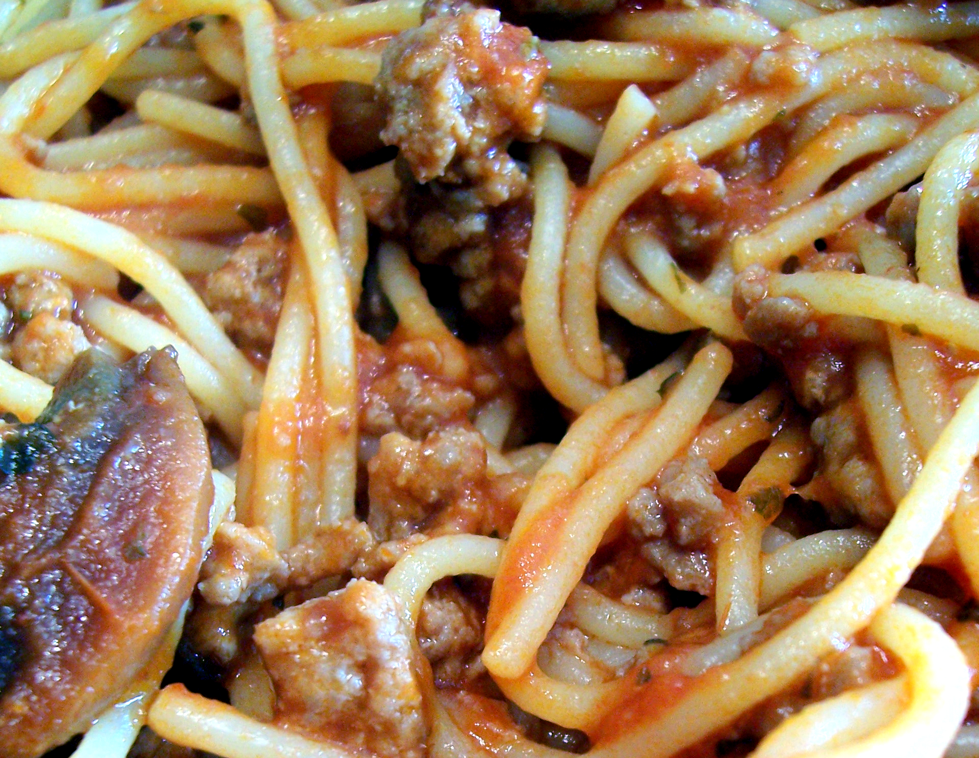 a close up of noodles with meat and sauce