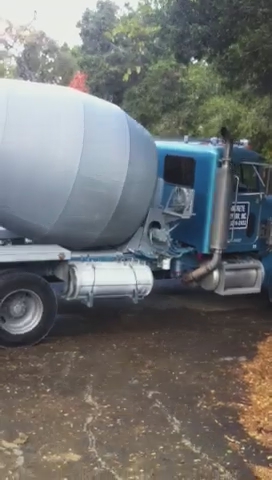 the truck is carrying an oversized cement bowl