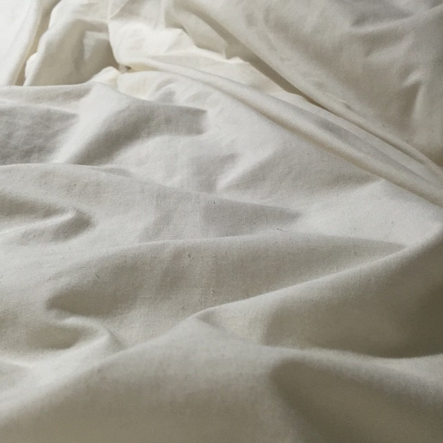 a bed is covered with a white comforter