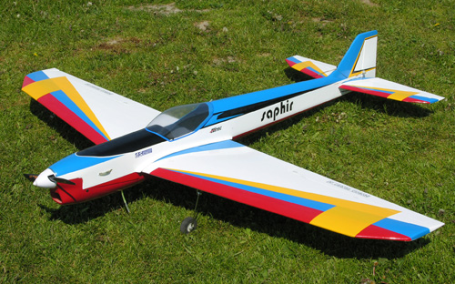 an airplane painted with different colors sitting on the grass