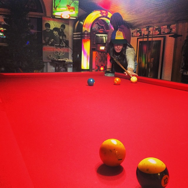 a woman with two balls playing pool