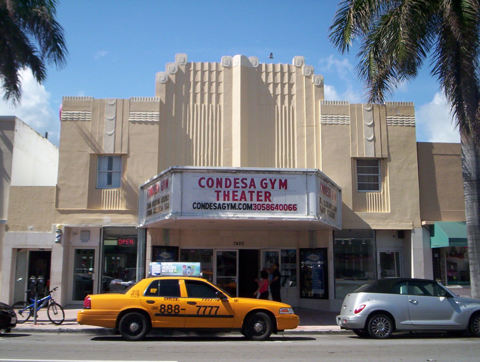 there is a taxi cab that stopped in front of a theater