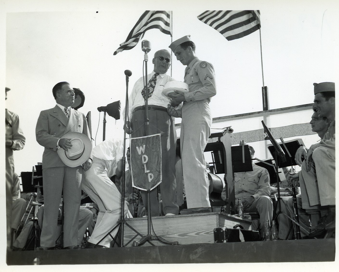 a vintage po of two men standing on a stage with flags in the background