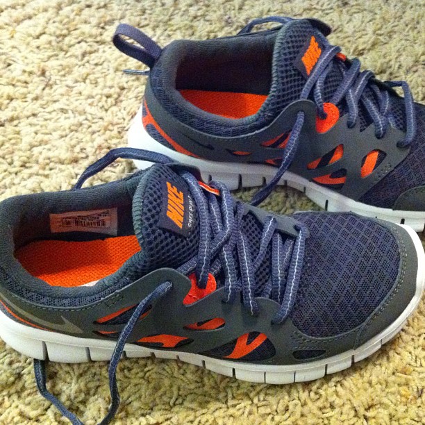 a pair of running shoes that are on the carpet