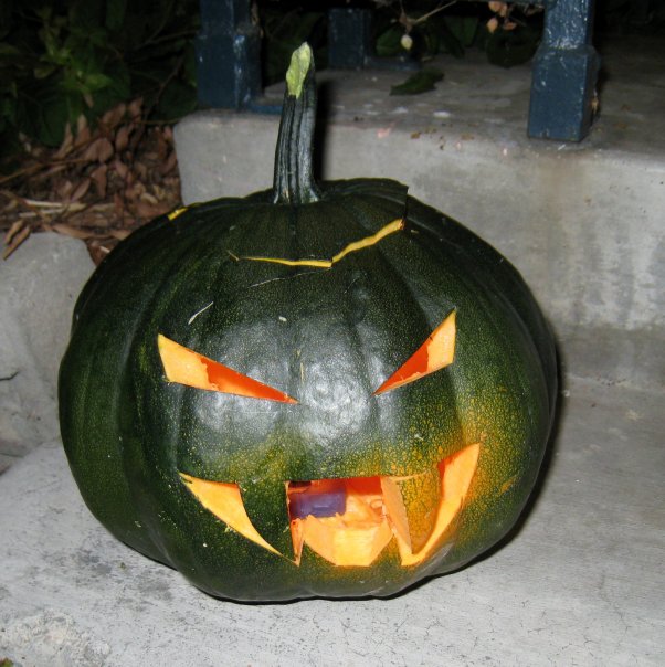 a carved pumpkin with teeth is sitting on a ledge