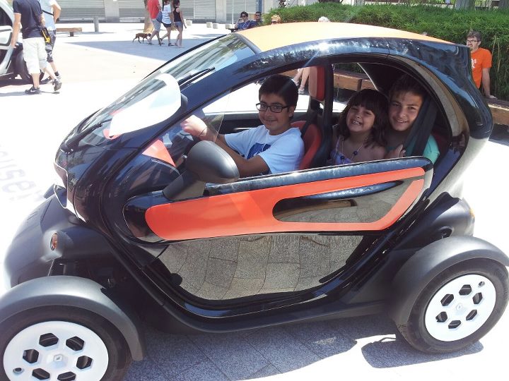 three s are smiling while riding an electric car