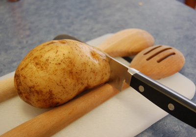 a potato and a knife on a  board