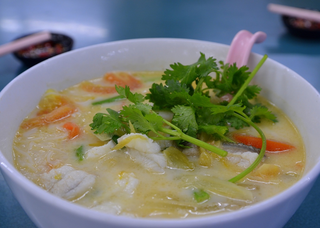 bowl of food with parsley in it on a blue table