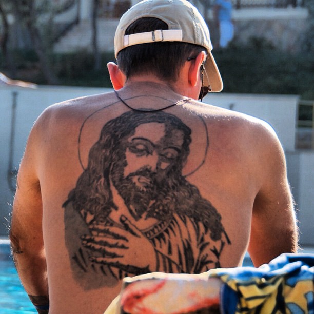 a man with a tattoo that has a picture of a jesus on it