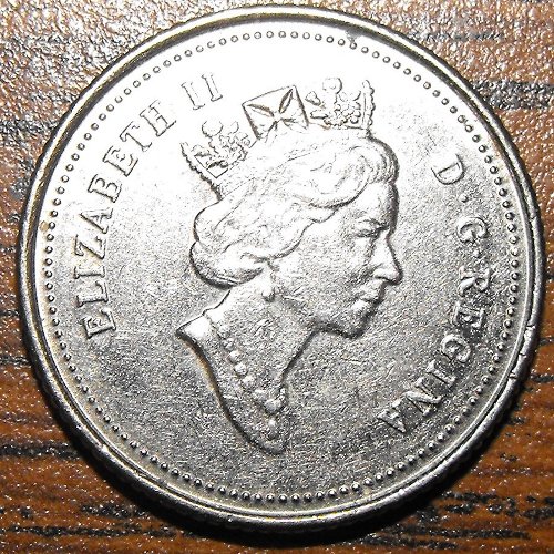 an old, silver metal piece with the head of queen elizabeth