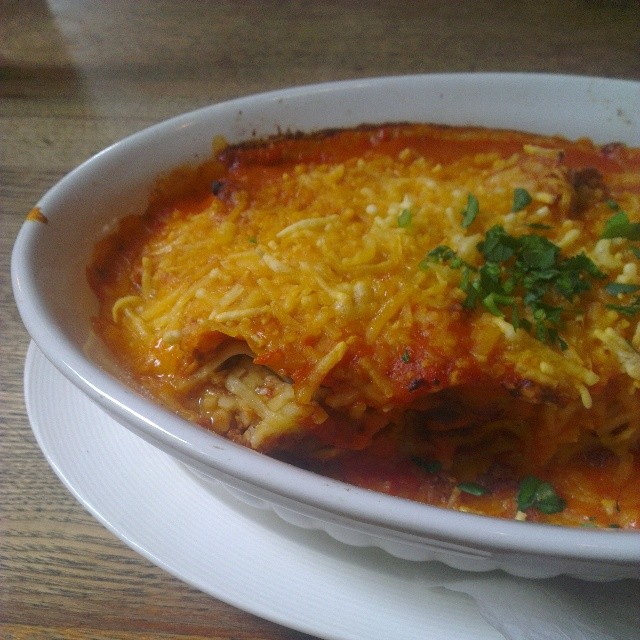 a white bowl filled with cheesy enchilada