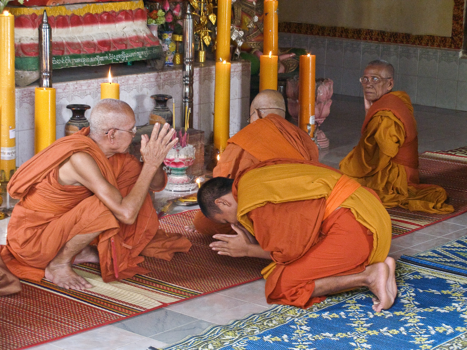two monks praying together on a rug in a religious area
